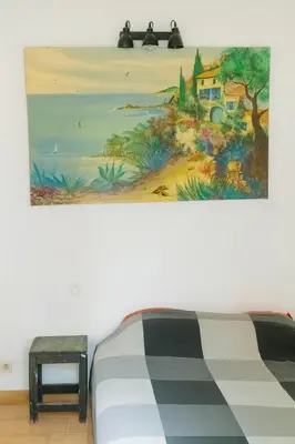 a painting hanging above a bed in a room at Le Cabanon Provençal Traditionnel Jardin Barbecue & Cheminée in Saumane-de-Vaucluse