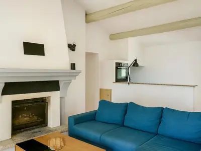 a blue couch in a living room with a fireplace at Le Cabanon Provençal Traditionnel Jardin Barbecue & Cheminée in Saumane-de-Vaucluse