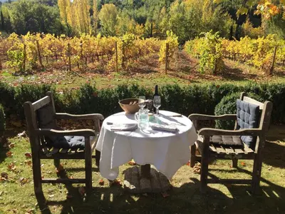 a table with two chairs and a bottle of wine at La Cour Intérieure Ménerbes in Ménerbes