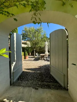 an archway leading into a courtyard with a bench at La Cour Intérieure Ménerbes in Ménerbes