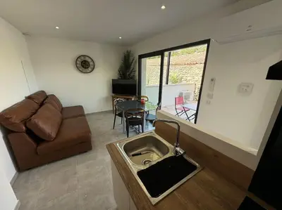 a living room with a couch and a sink at Appartement neuf centre du village in Le Puy-Sainte-Réparade