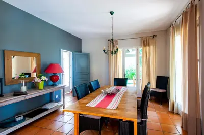 a dining room with a wooden table and blue walls at Villa-Provence-Pont-Royal in Mallemort
