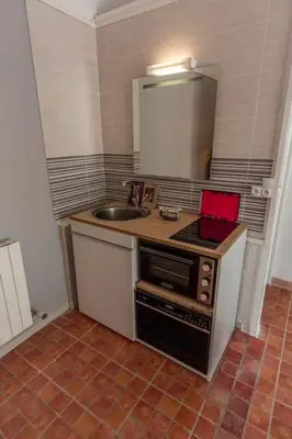 a small kitchen with a sink and a stove at Joli Studio 36m2 tout confort in Châteauneuf-de-Gadagne