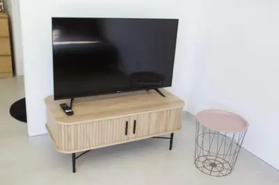 a tv sitting on top of a wooden tv stand at Villa Luberon 3ch piscine jardin parking in Saignon