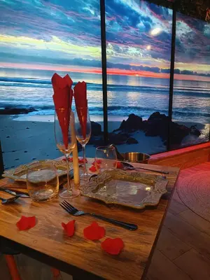 a table with wine glasses and red roses on it at Multiverse Suite immersive in Charleval