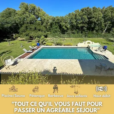 a swimming pool in a park with a sign next to it at Belle villa provençale et dépendances dans un domaine de 2 Ha piscine, sauna, balnéo in Grans