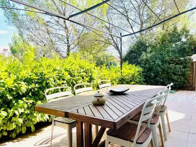 a wooden table and chairs in a garden at Maison haut de gamme dans le golf de pont royal in Mallemort
