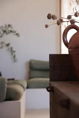 a living room with a couch and a vase with a flower at Casa Pauseto in Bonnieux