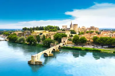 a bridge over a river with a city in the background at Mazet Cordelles Alpilles in Eygalières