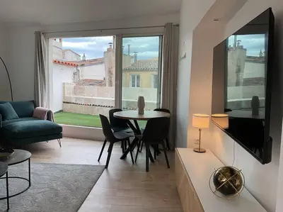 a living room with a tv and a table and chairs at Duplex rénové comme Neuf à Aix-en-Provence in Aix-en-Provence