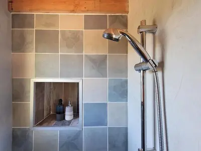 a shower with a shower head in a bathroom at Ecolieu Silenciane in Simiane-la-Rotonde