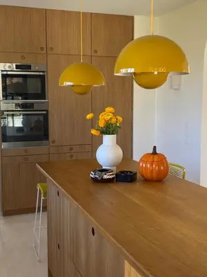 a kitchen counter with a vase of flowers and a pumpkin at Mas Au pays des Alpilles in Eygalières