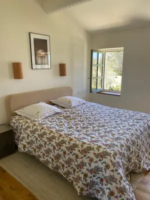 a bedroom with a bed with a floral bedspread at Mas Au pays des Alpilles in Eygalières