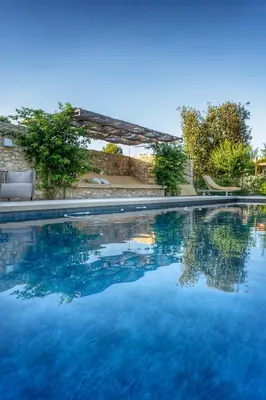 a swimming pool with blue water at Mas Au pays des Alpilles in Eygalières