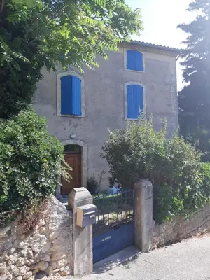 a house with blue windows and a mailbox in front of it at Maison de village provençale in Monieux
