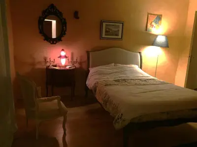 a bedroom with a bed and a table with a lamp at Maison de village provençale in Monieux