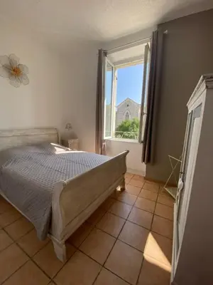 a bedroom with a bed and a window at Limasola - Apartment and its rooftop in Les Vignères