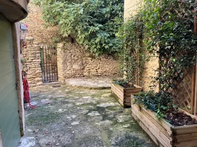 an alley with a brick wall and some plants at La Magnanerie in Cabrières-dʼAvignon