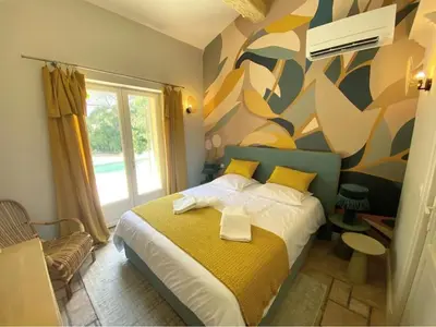 a bedroom with a bed with a colorful wall at Domaine Farandole in Eygalières