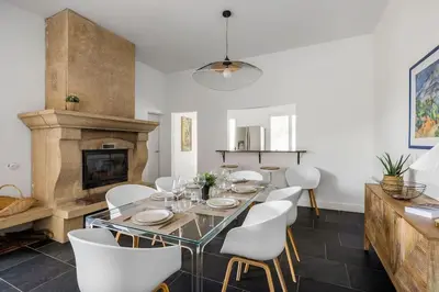 a dining room with a table and chairs and a fireplace at Villa La Pinède in Aix-en-Provence