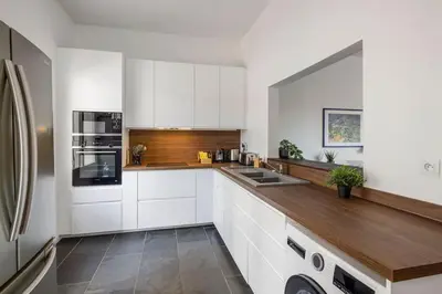 a kitchen with white cabinets and a wooden counter top at Villa La Pinède in Aix-en-Provence
