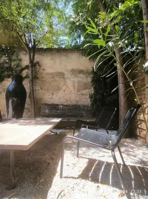 a chair sitting next to a table and a bench at Magnifique maison de ville 6personnes , piscine et garage in Aix-en-Provence