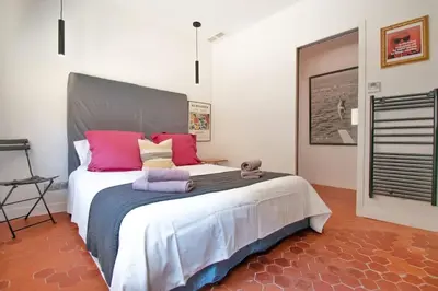 a bedroom with a large bed with pink and purple pillows at Magnifique maison de ville 6personnes , piscine et garage in Aix-en-Provence