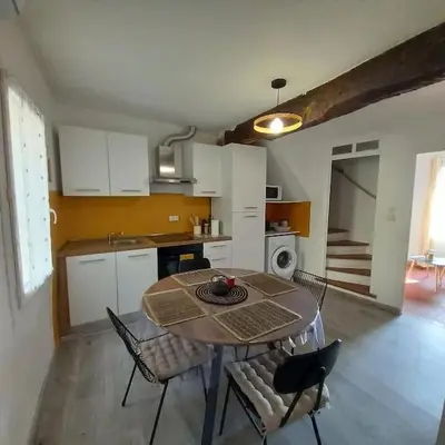 a kitchen and dining room with a table and chairs at Le petit gîte de Rosalie in Blauvac