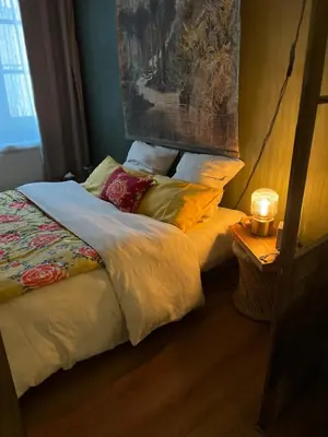 a bed in a bedroom with a lamp on a table at Chambre style balinais in Aix-en-Provence