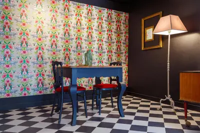 a dining room with two chairs and a table with a floral wallpaper at Ritournelle en Provence 19 personnes 4 étoiles in Pernes-les-Fontaines