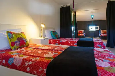 a bedroom with two beds and a living room at Ritournelle en Provence 19 personnes 4 étoiles in Pernes-les-Fontaines