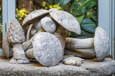 a stone statue of a group of mushrooms at La maison de la piscine in Goult