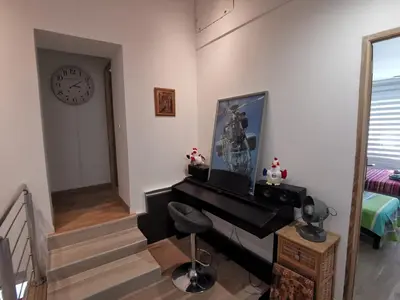a living room with a piano and a clock at Maison Aix en Provence et grand jardin in Aix-en-Provence