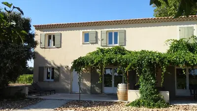 a house with a bunch of vines on the side of it at Gîte au coeur du vignoble des Saumanes in Châteauneuf-de-Gadagne