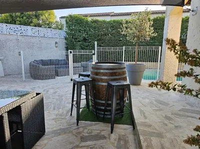a barrel sitting on a patio with two stools at Paradise Corner in LʼIsle-sur-la-Sorgue