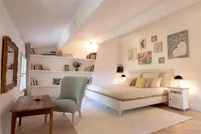 a bedroom with a bed and a chair and a table at Domaine de la Lisière in Sault-de-Vaucluse