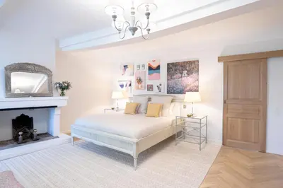 a white bedroom with a bed and a fireplace at Domaine de la Lisière in Sault-de-Vaucluse