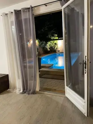 an open door with a view of a swimming pool at Grand studio avec piscine au coeur du village in Le Puy-Sainte-Réparade