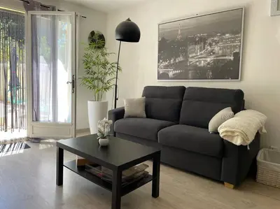 a living room with a couch and a coffee table at Grand studio avec piscine au coeur du village in Le Puy-Sainte-Réparade
