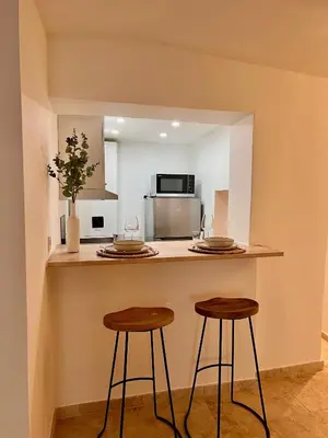 a kitchen with two stools and a counter with a microwave at coeur du Luberon in Lourmarin