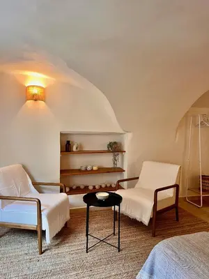 a bedroom with two white chairs and a table at coeur du Luberon in Lourmarin