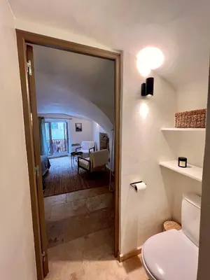 a bathroom with a door leading to a living room at coeur du Luberon in Lourmarin