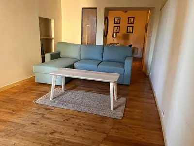 a living room with a blue couch and a coffee table at Maison de ville avec rooftop vue sur le Ventoux in Monteux