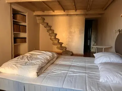 a large bed in a room with a stone wall at Maison de ville avec rooftop vue sur le Ventoux in Monteux