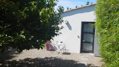 a white building with a door and a plant at le gîte Lou Jas in Eyragues