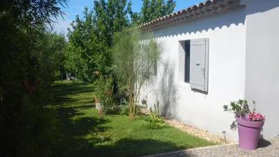 a white house with a window and a yard at le gîte Lou Jas in Eyragues