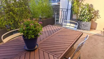 a wooden table with a potted plant on a balcony at Chambre Voltaire ou Chambre Beckett, terrasse en bord de Sorgue in Le Thor