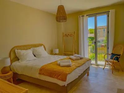 a bedroom with a bed and a large window at Villa Mathilde, un meublé de tourisme 3 étoiles au cœur de Goult in Goult