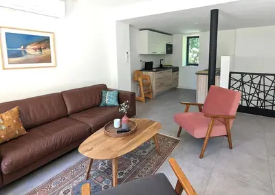 a living room with a brown couch and a table at Évasion Moderne en Provence in Lambesc