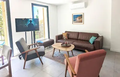 a living room with a couch and a table at Évasion Moderne en Provence in Lambesc